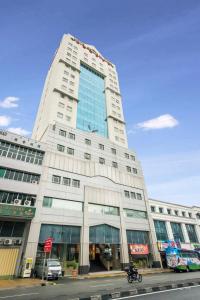 un edificio blanco alto en una calle de la ciudad en Hotel Sentral Pudu @ City Centre / Bukit Bintang, en Kuala Lumpur