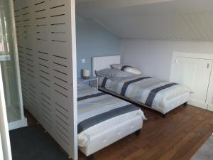 two twin beds in a room with a wall at Chambres d'Hôtes Selon Morphee in Selongey