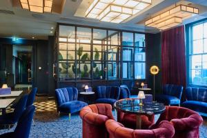 a waiting room with blue chairs and a table at Le Monde Hotel in Edinburgh