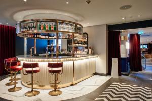 a bar in a hotel with red bar stools at Le Monde Hotel in Edinburgh