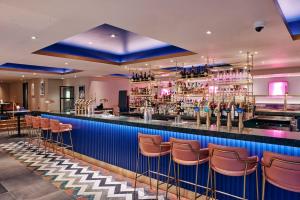 a bar with orange stools in a restaurant at Le Monde Hotel in Edinburgh
