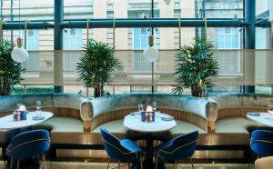 a restaurant with tables and chairs and windows at Le Monde Hotel in Edinburgh