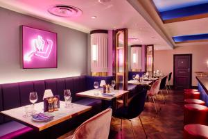 a row of tables in a restaurant with purple lighting at Le Monde Hotel in Edinburgh
