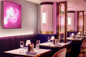 a dining room with tables and chairs with wine glasses at Le Monde Hotel in Edinburgh