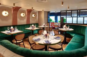 a restaurant with green furniture and tables and chairs at Le Monde Hotel in Edinburgh