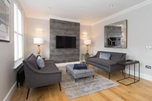 a living room with a couch and a chair and a tv at Belford by Harrogate Serviced Apartments in Harrogate