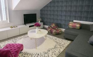 sala de estar con sofá y mesa en Sanderson Suites en Harrogate