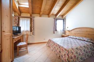 Dormitorio con cama, escritorio y TV en Park Hotel Villa Giustinian, en Mirano