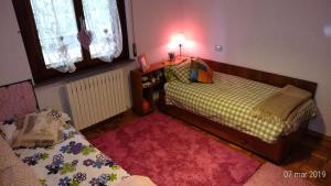 una camera con 2 letti e un tappeto rosso di Residenza Montevile di Spaccini Gabriella a Ponte San Giovanni