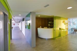 a lobby with green and white walls and a reception desk at Alsol Walhalla in Playa del Ingles +40 photos