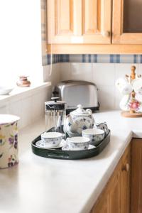 un plateau de vaisselle sur un comptoir dans une cuisine dans l'établissement Unique cosy cottage with stunning gardens, à Musselburgh