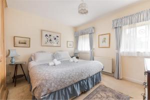 a bedroom with a bed and two windows at Unique cosy cottage with stunning gardens in Musselburgh
