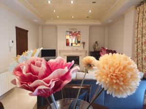 een woonkamer met bloemen in een vaas op een tafel bij Alojamiento El Olivo in Ronda
