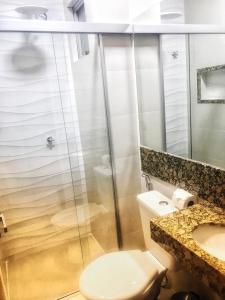 a bathroom with a shower and a toilet and a sink at Paradise Temporada Cobertura 4 Quartos com Jacuzzi e Churrasqueira no Thermas Paradise - Rio Quente in Rio Quente