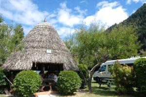 a group of people sitting at a table in a hut at Queenstown Holiday Park Creeksyde in Queenstown