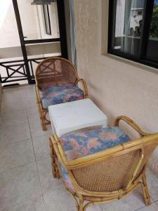 a wicker chair with a white table on a patio at Antilla Villa on beach in Flic-en-Flac