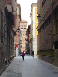 Un par de personas caminando por una calle en Apartamentos Turisticos Torico Amantes, en Teruel