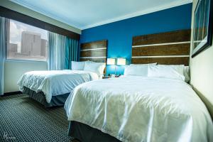 Holiday Inn Houston Downtown, an IHG Hotel في هيوستن: غرفة فندقية بسريرين ونافذة