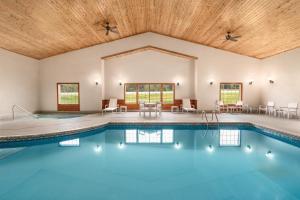 une grande piscine intérieure avec un plafond en bois dans l'établissement Country Inn & Suites by Radisson, Detroit Lakes, MN, à Detroit Lakes