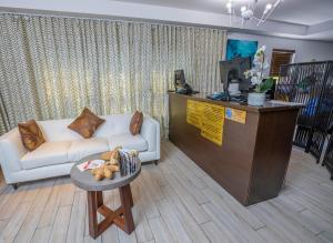 een woonkamer met een witte bank en een tafel bij Seaside All Suites Hotel in Miami Beach