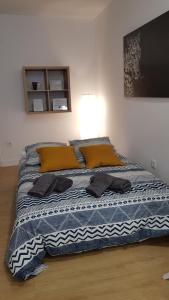 a bed with a blue and white blanket and a lamp at Loft Yolanda Centro in Cuenca