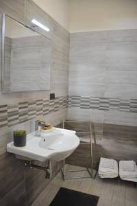 een badkamer met een witte wastafel en een spiegel bij B&B Le due Rose (Pompei) in Pompei