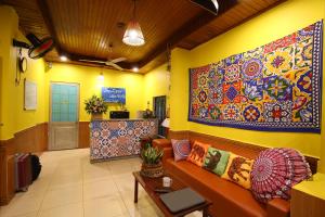 un vestíbulo con sofá y una gran pintura en la pared en Longan Homestay, en Hoi An
