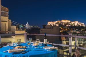 Syntagma Spa with Acropolis View في أثينا: طاولة مع زجاجة من النبيذ وكؤوس النبيذ