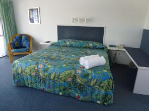 a hotel room with a bed and a desk at Mana-Nui Motel in Whitianga