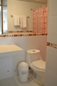 a bathroom with a toilet and a sink and a mirror at Suite Service Apart Hotel in Lima