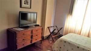 un televisor sentado en un tocador en un dormitorio en Suite Service Apart Hotel, en Lima