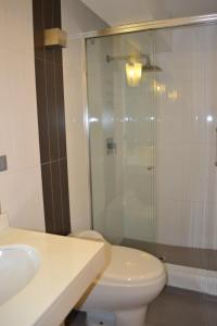 a bathroom with a toilet and a glass shower at Suite Service Apart Hotel in Lima