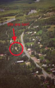 a view of a road with a sign that says we are her at Linsell in Sveg