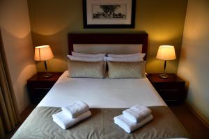 um quarto com uma cama com duas almofadas em WeStay Westpoint Apartments em Joanesburgo