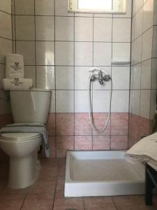La salle de bains est pourvue d'une douche, de toilettes et d'une baignoire. dans l'établissement Villa Miranda, à Kerion