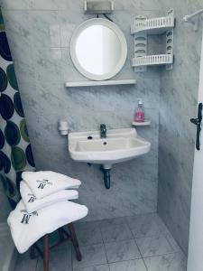 La salle de bains est pourvue d'un lavabo, d'un miroir et de serviettes. dans l'établissement Villa Miranda, à Kerion