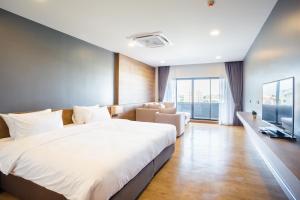 um quarto com uma cama grande e uma sala de estar em Icon Park Hotel, Chiang Mai- SHA Extra Plus em Chiang Mai