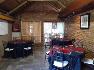 une salle dotée de tables et de chaises avec des nappes rouges et bleues dans l'établissement revival guest house, à Klerksdorp