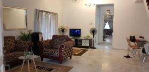 sala de estar con 2 sillas y TV en Tun Perak Homestay en Rawang