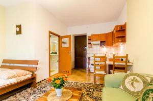 Una sala de estar con un sofá y una mesa con flores. en Libro Rooms, en Cracovia