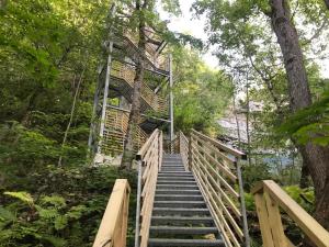 a wooden stairway leading up to a bridge in a forest at Valaste Puhkeküla in Kohtla-Järve