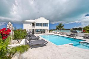 a villa with a swimming pool and a house at Neptune Villas in Five Cays Settlement