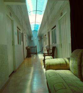einen Flur mit Sofas und einem Oberlicht in einem Gebäude in der Unterkunft Hotel Ciudad Señora Buga in Buga