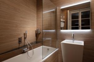 La salle de bains est pourvue d'une baignoire, d'une douche et d'un miroir. dans l'établissement SUITE 1907 OVIEDO Low Cost, à Oviedo