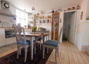 a kitchen with a wooden table and chairs at Beletage in Bølshavn