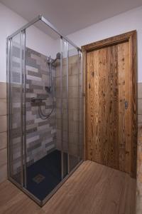 una ducha con puerta de cristal en una habitación en Chalet Golf Campiglio / LuxApt / fronte piste-impianti-golf, en Madonna di Campiglio