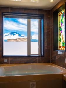 富士河口湖的住宿－太陽別墅，带浴缸的浴室和窗户