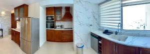 a kitchen with wooden cabinets and a stainless steel refrigerator at Modern 2 bed room large apartment in Nicosia +33 photos