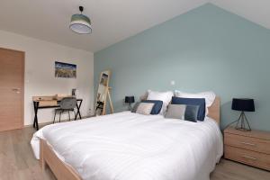 a bedroom with a large white bed and a desk at Gîte de Munt'Z SPA, Sauna, piscine, proche de Colmar in Muntzenheim