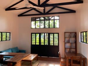 a living room with a table and a ceiling fan at Lilac Hideaway in Karatu